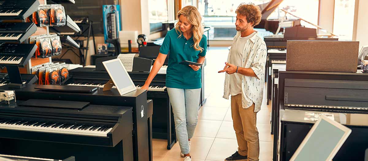 A man at a piano shop with a saleslady