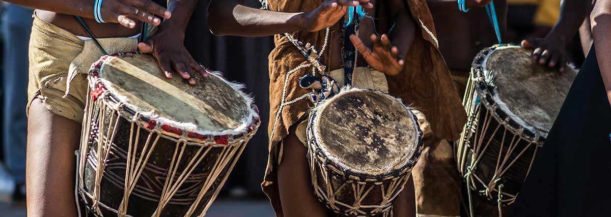 African tribe playing drums made out of wood