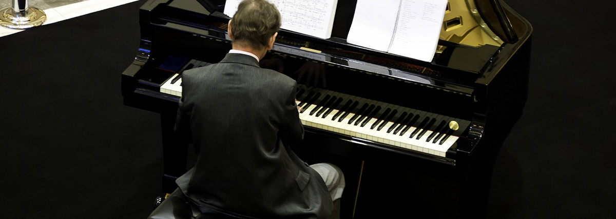 Back view of pianist playing the grand piano