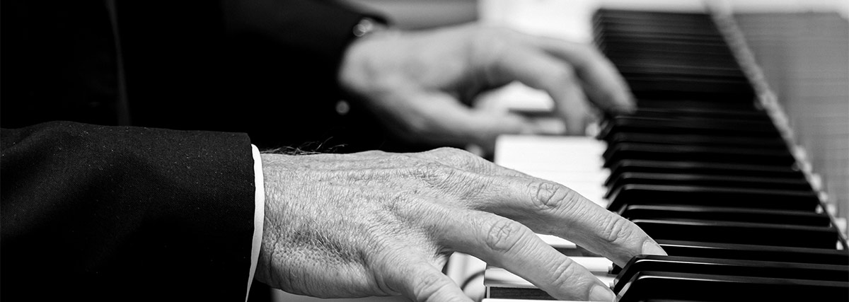 Black and white hands on piano keyboard