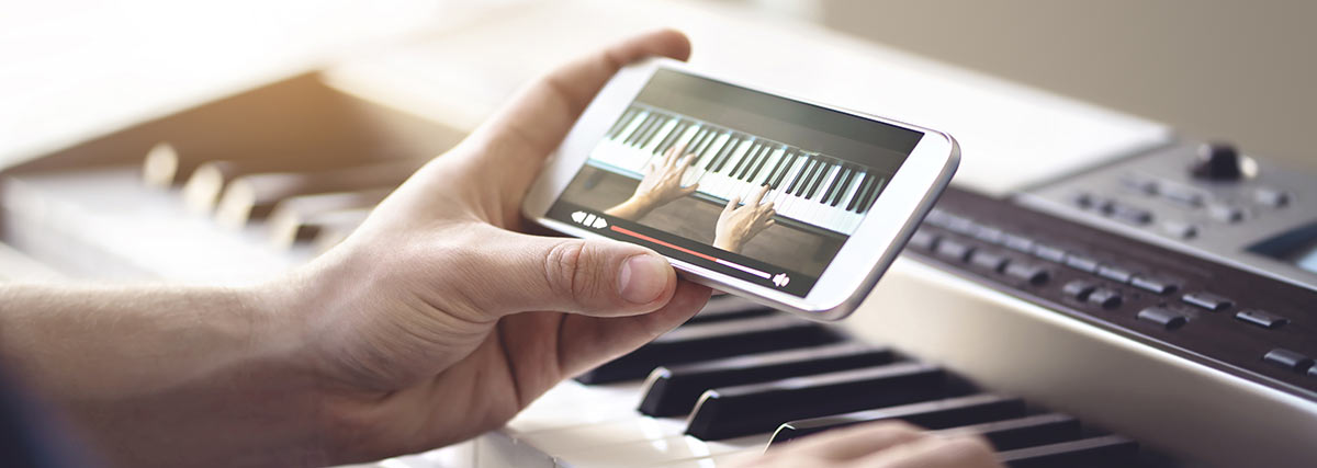 hand holding moblie phone with piano