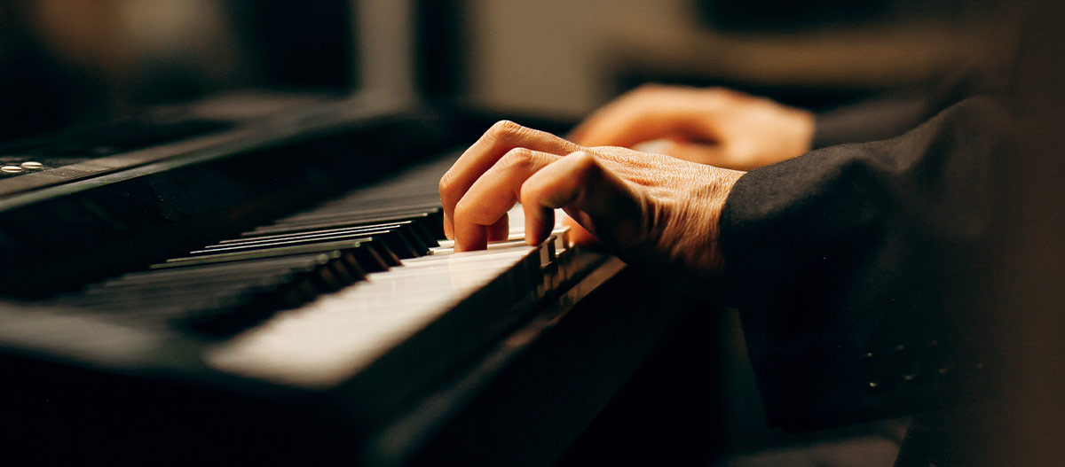 Hand pressing the piano keyboard