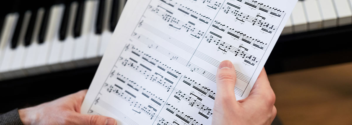 Hands holding music sheet