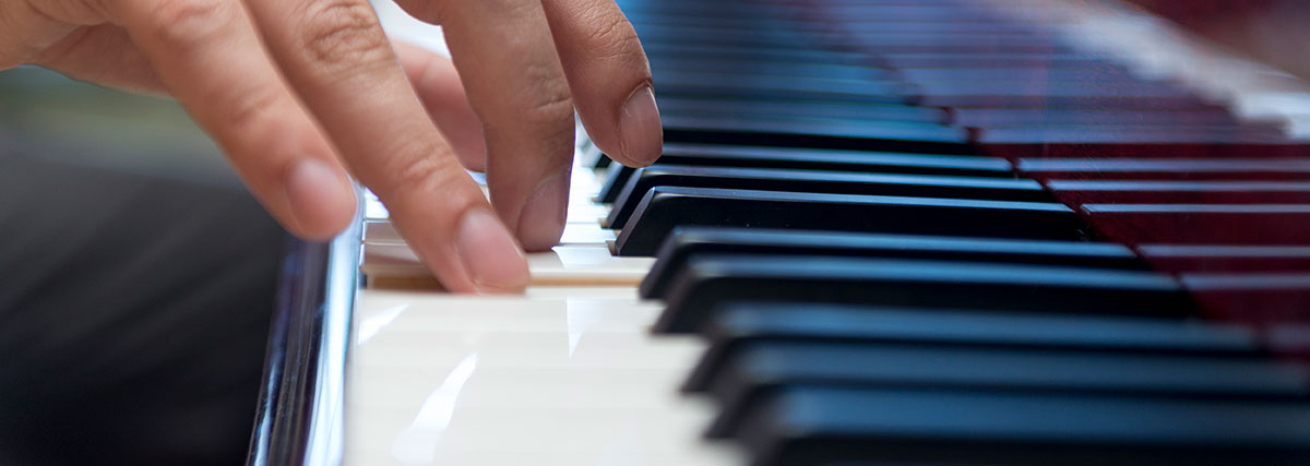 Hands playing piano keys