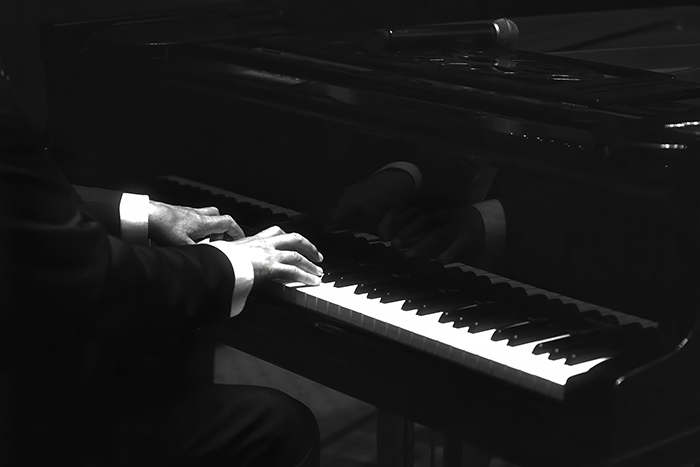 Male hands on piano keyboard black and white