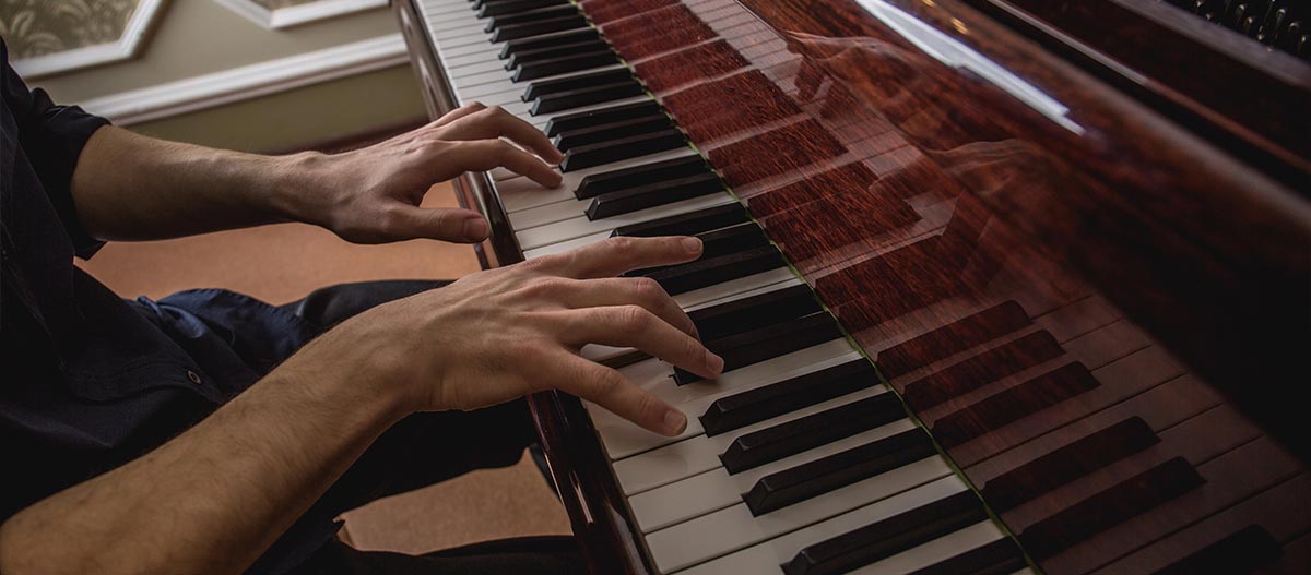 Male hands playing the acoustic piano