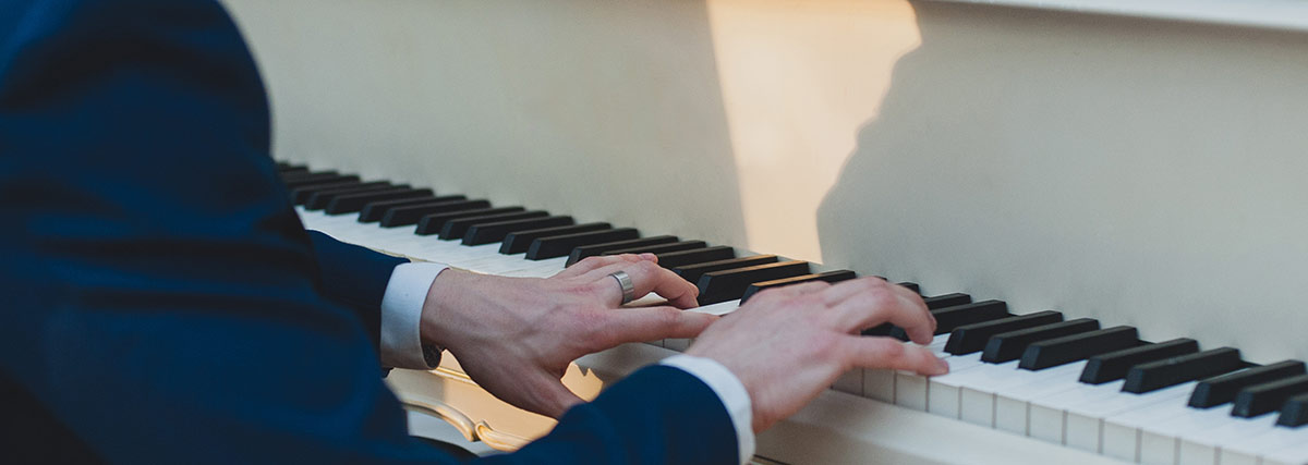 male pianist hands on grand piano