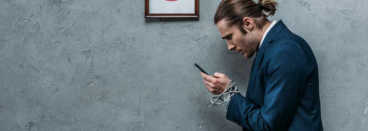 man holding phone with cables wrapped around wrists