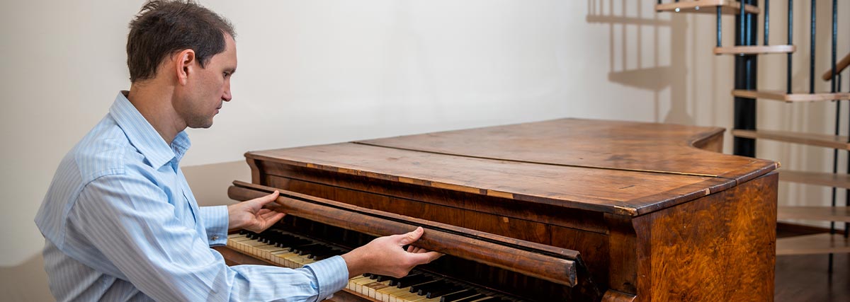 Man opening the piano keyboard cover