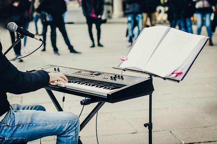 Man playing piano busking on the street