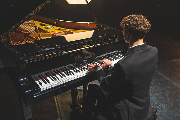 Man playing the grand piano feat