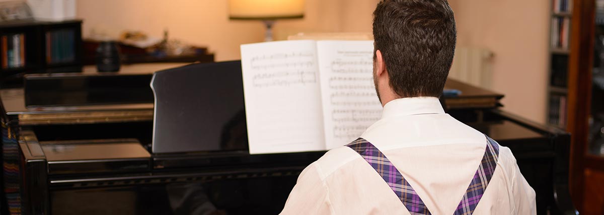 man practising piano at home