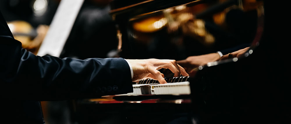 Pianist playing on a grand piano on stage