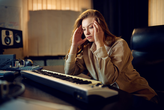Sad woman staring at the piano feat