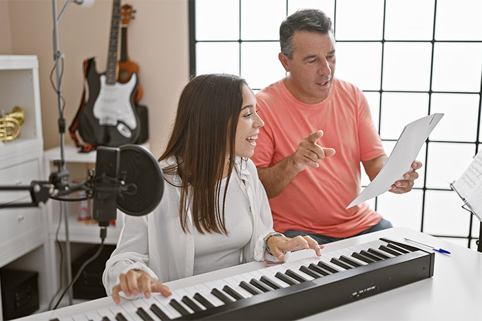 Teacher and student having piano lesson feat