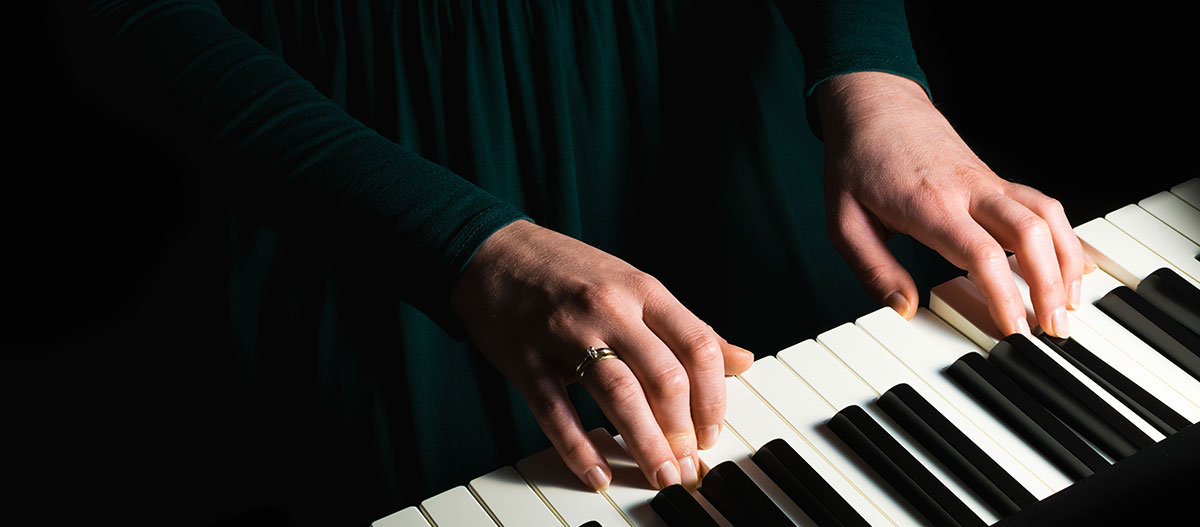 Woman hands on the piano keyboard