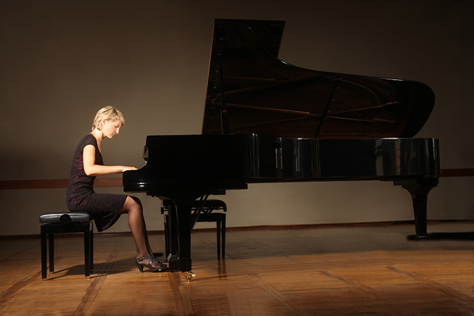 Woman performing the piano in front of an audience
