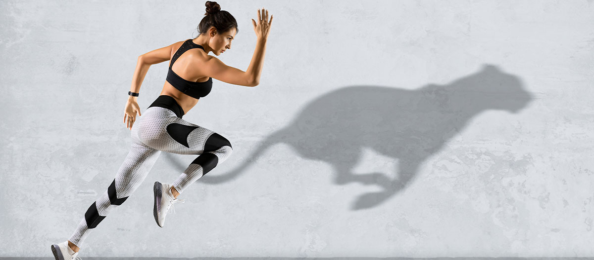 Woman running on grey wall background sportswear