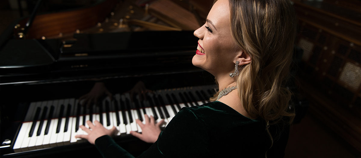 Woman smiling and playing piano