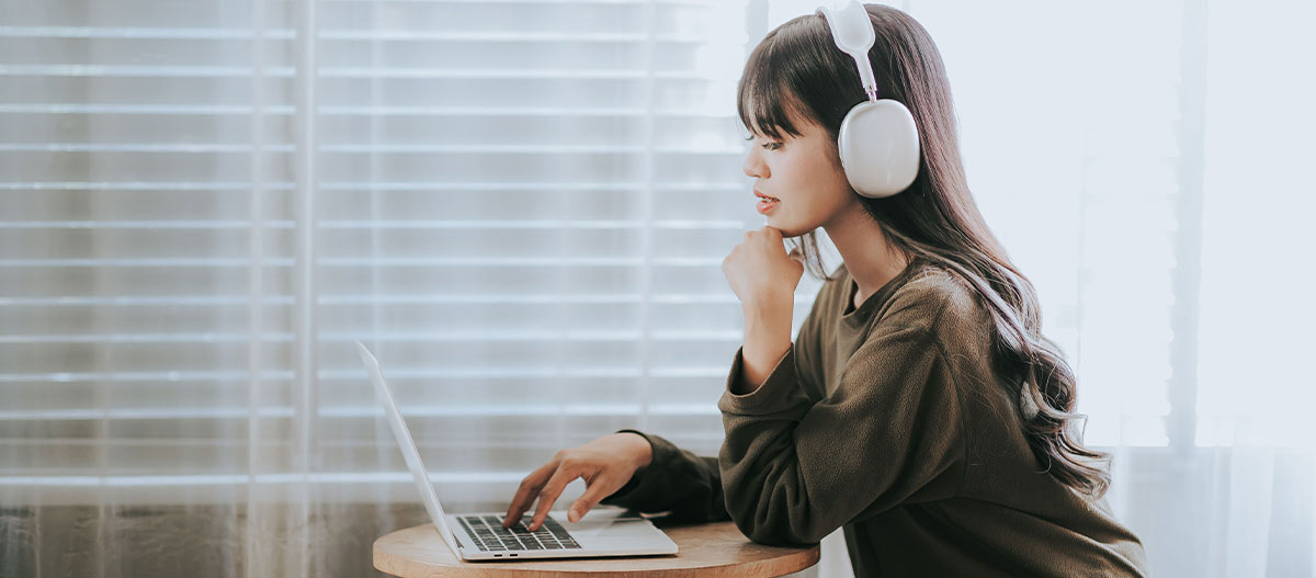 Woman with laptop and wearing headphones