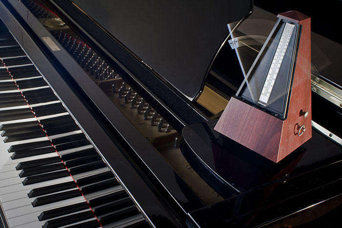 Wooden metronome on a grand piano feat